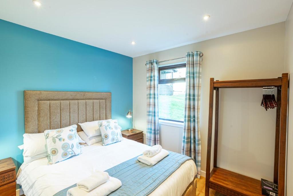 a bedroom with a bed with towels on it at Birch Lodge in Newton Stewart