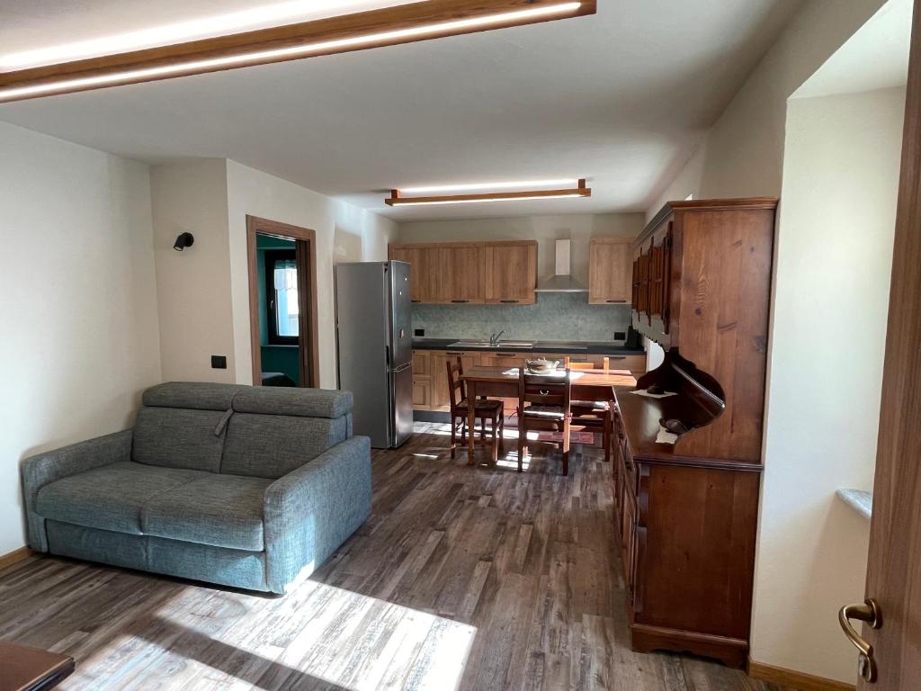 ein Wohnzimmer und eine Küche mit einem Sofa und einem Tisch in der Unterkunft Casa Carral in Aymavilles