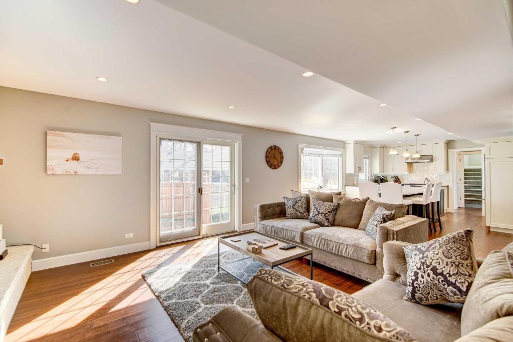 a living room with a couch and a table at Classy Lakefront Home with Charcoal Grill and Deck! in Prospect Heights