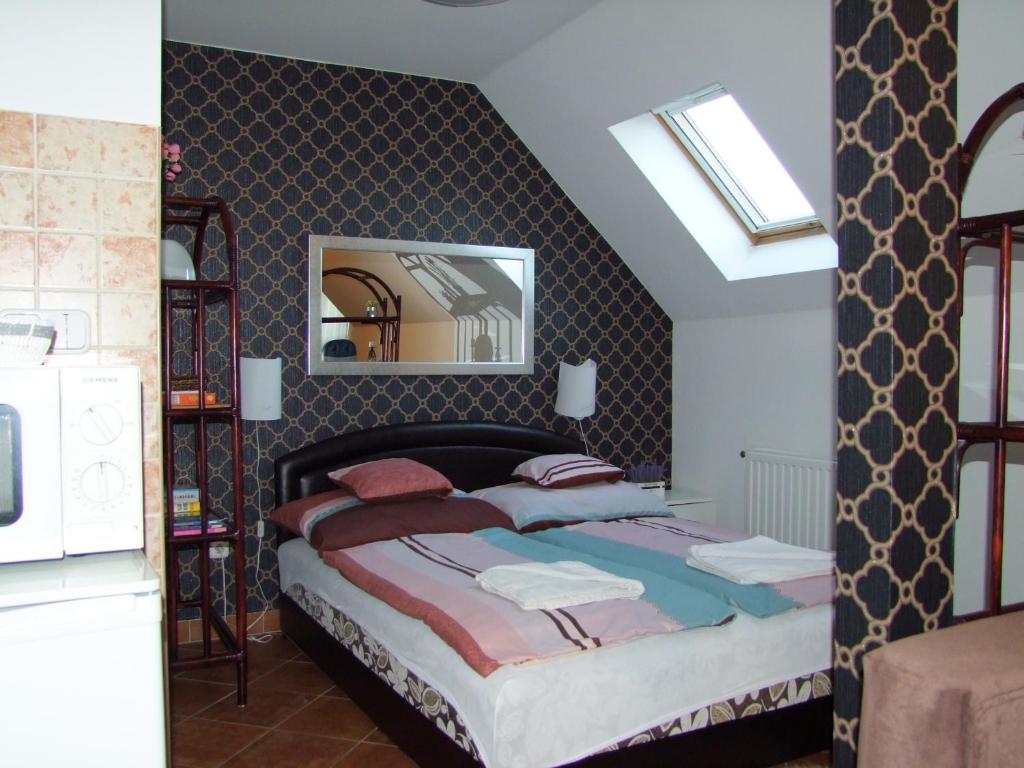 a bedroom with a large bed with a mirror at Gréta Apartman in Hajdúszoboszló