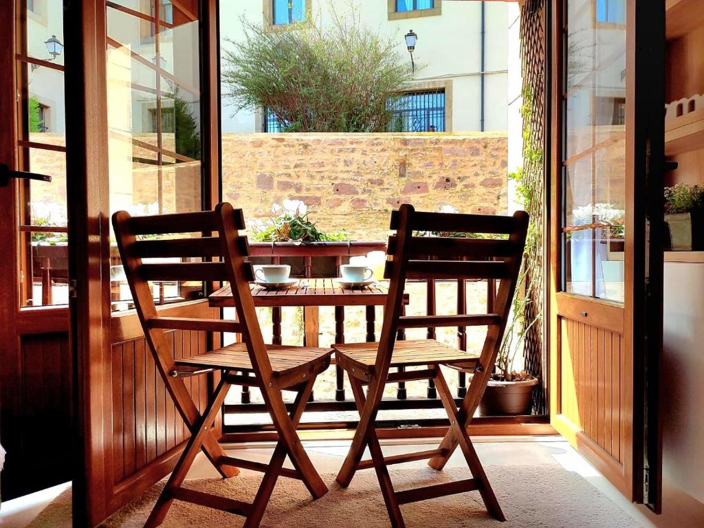 2 sillas de madera sentadas en una mesa en un porche en Nuevo-Casco Histórico-Parking gratuito. en Oviedo