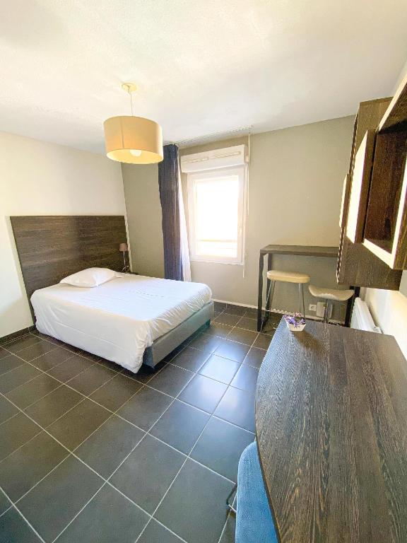 Habitación de hotel con cama y mesa en City Résidence Nice en Niza