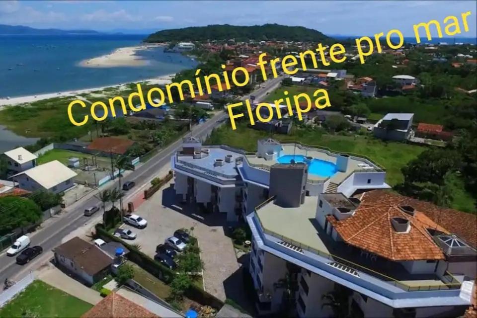 Vista árida de una mansión con las palabras condamina en Apto Ponta das Canas - Floripa en Florianópolis