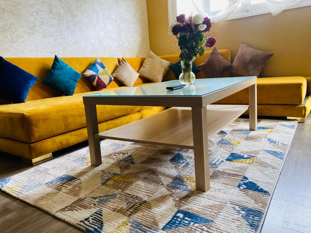 uma mesa de centro numa sala de estar com um sofá amarelo em Beautiful Apartment in the City Center with Everything You Need em Tânger