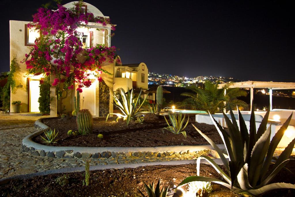 a building with a clock tower at night at Thea Luxury Resort in Fira