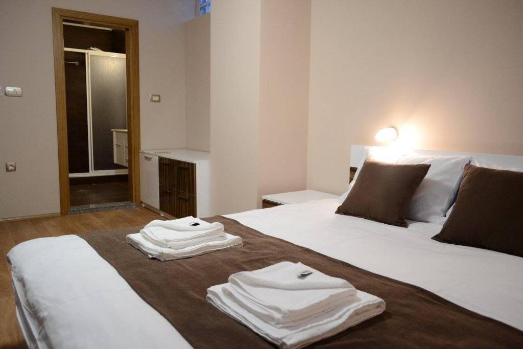 two white towels are sitting on top of two beds at City House Bitola in Bitola