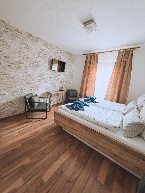 a bedroom with a bed and a chair in a room at Landhotel "Schwarzach am Main" in Schwarzach am Main