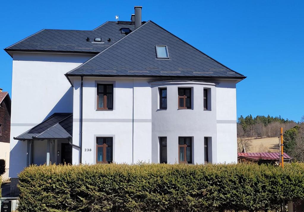 een wit huis met een zwart dak bij Vila Quantum Bohemia in Vyšší Brod