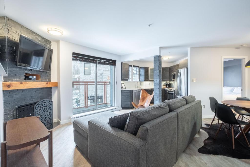 a living room with a couch and a fireplace at Eagle Lodge 225 by Outpost Whistler in Whistler