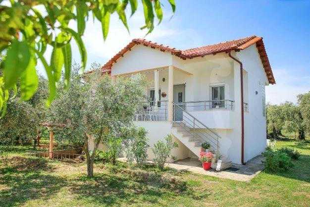 a white house with a staircase in a yard at Elena's Suite in Skala Rachoniou