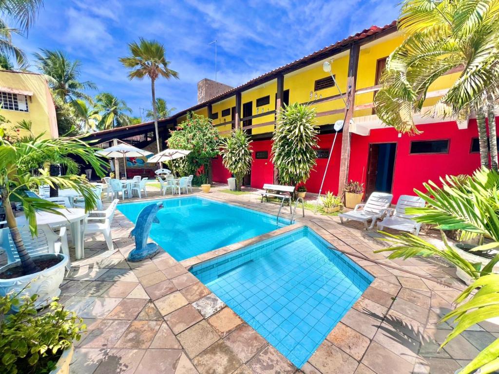 ein Resort mit einem Pool und einem Gebäude in der Unterkunft Pousada Bon Vivant in Porto De Galinhas