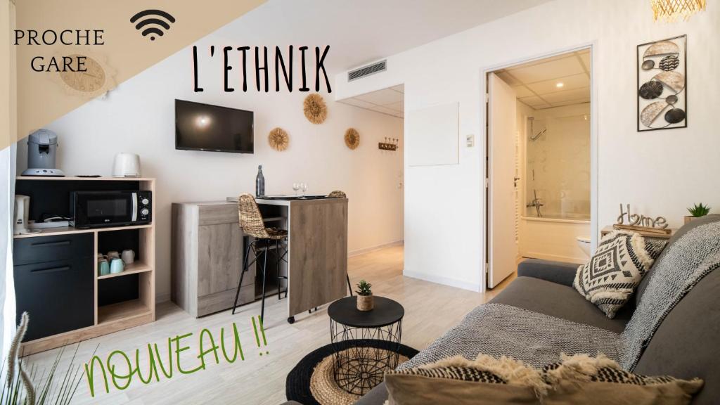 a living room with a couch and a tv on a wall at L'ETHNIK--STUDIO TOUT CONFORT--CLIM--PARKING--WIFi in Lourdes