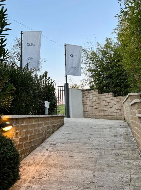 two white flags on a brick wall with a gate at Casale Terre Rosse in Saturnia