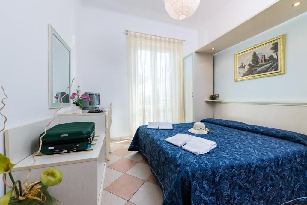 una camera con letto e piumone blu di Hotel Bruna a Martinsicuro