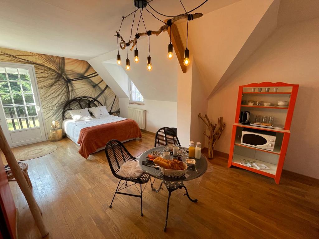 Schlafzimmer mit einem Bett, einem Tisch und Stühlen in der Unterkunft Belle Chambre Double ORANGE Tout Bonnement Bien in Putot-en-Auge