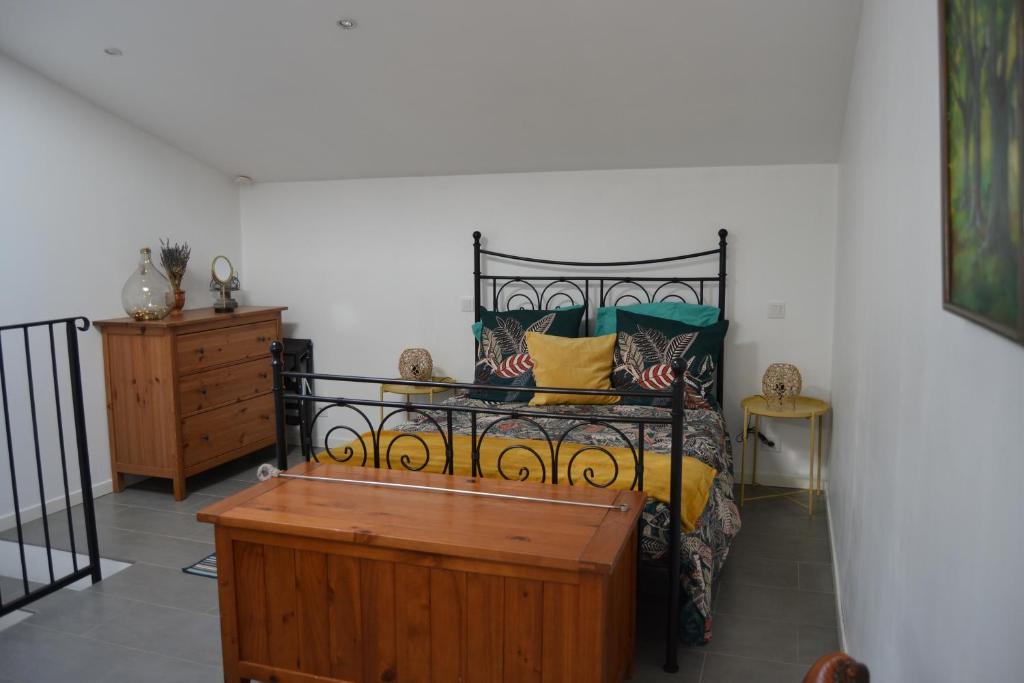 a bedroom with a bed and a wooden dresser at L'Oléastre en Luberon in Grambois