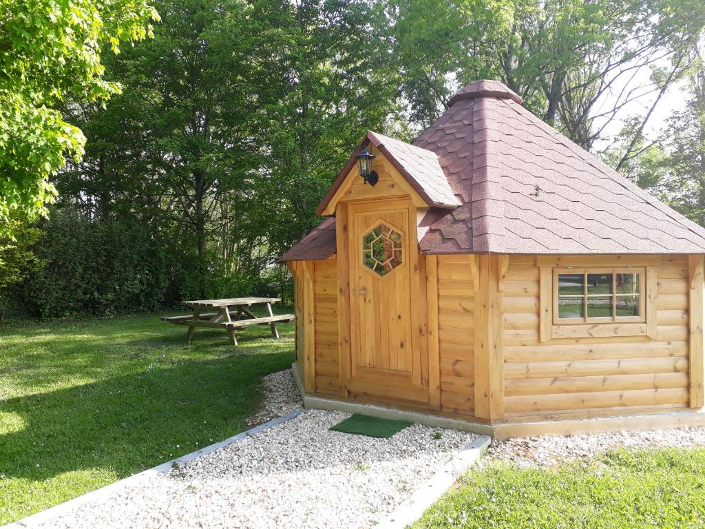 eine kleine Holzhütte mit einem Picknicktisch in einem Park in der Unterkunft Chambre KOTA Insolite in Attigny