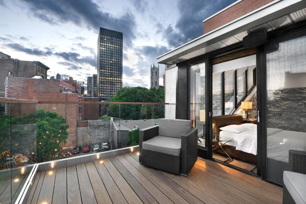 Un balcón con una cama y una silla en un edificio en Hotel Épik Montréal, en Montreal