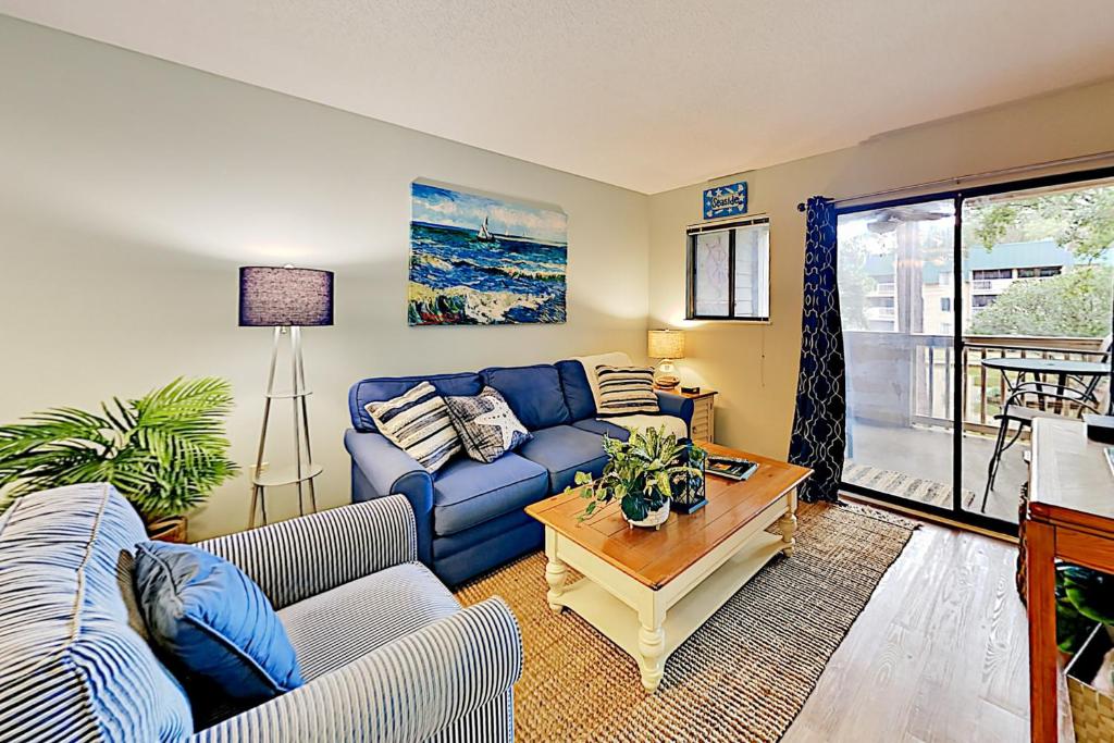 a living room with a blue couch and a table at Spa on Port Royal Sound IV in Hilton Head Island