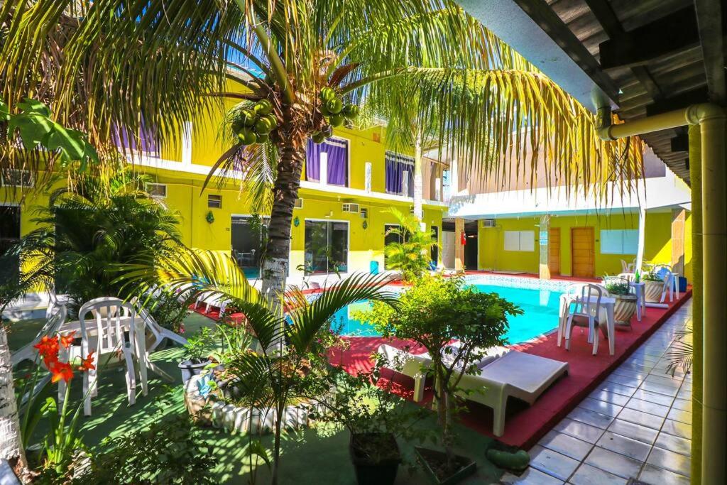 a resort with a pool and palm trees and chairs at Pousada Aquarius in Aruanã