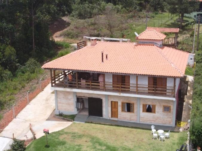 蒙特沃德的住宿－Casa Recanto Beija Flor, Monte Verde，享有橙色屋顶房屋的空中景致