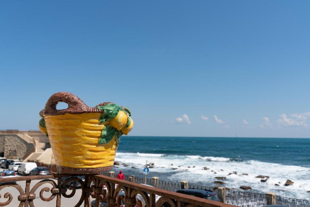 einen Korb auf einem Zaun am Strand in der Unterkunft Blue Levante Vista Mare con terrazza in Syrakus