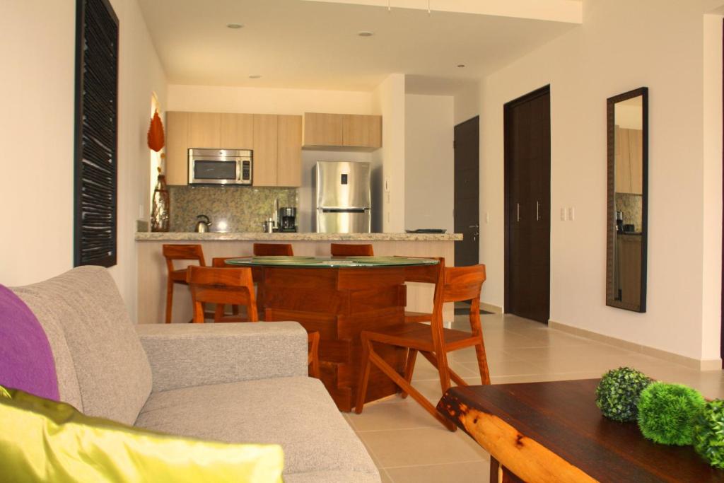 cocina y sala de estar con mesa y sillas en TAO Modern Retreat, en Akumal