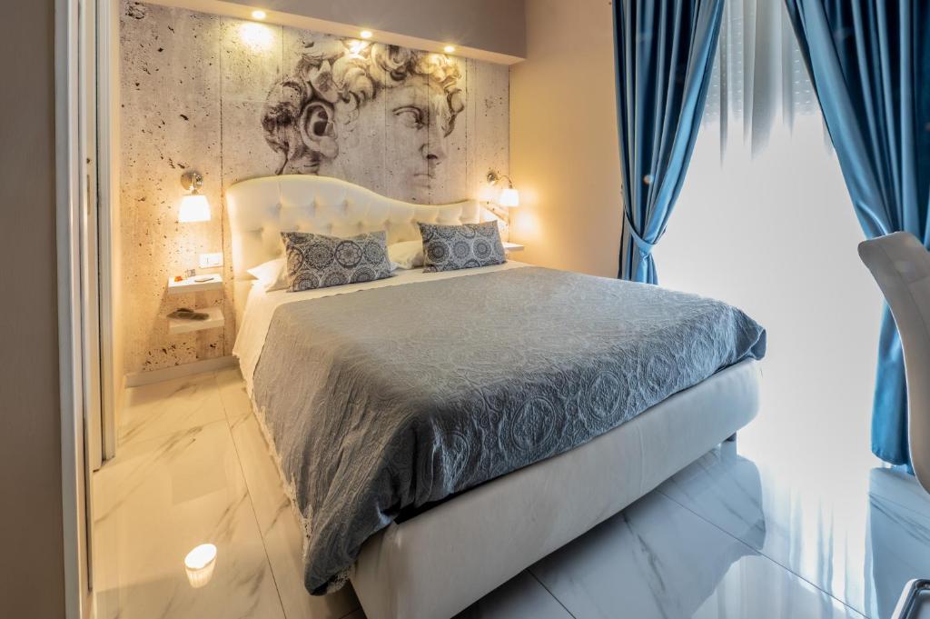 1 dormitorio con 1 cama grande y un retrato en la pared en Eolian Port B&B, en Milazzo