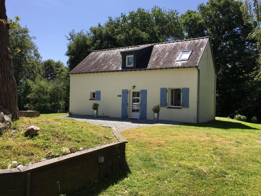 una pequeña casa blanca con puertas azules en un patio en Gites de kermoel, Ouessant, en Kernascléden