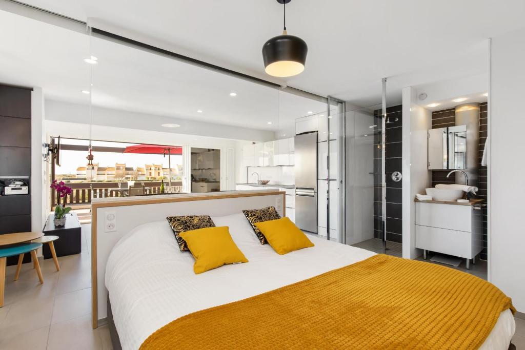een slaapkamer met een groot bed met 2 gele kussens bij Village Naturiste R4N - La Villa Rocca Luxe in Cap d'Agde
