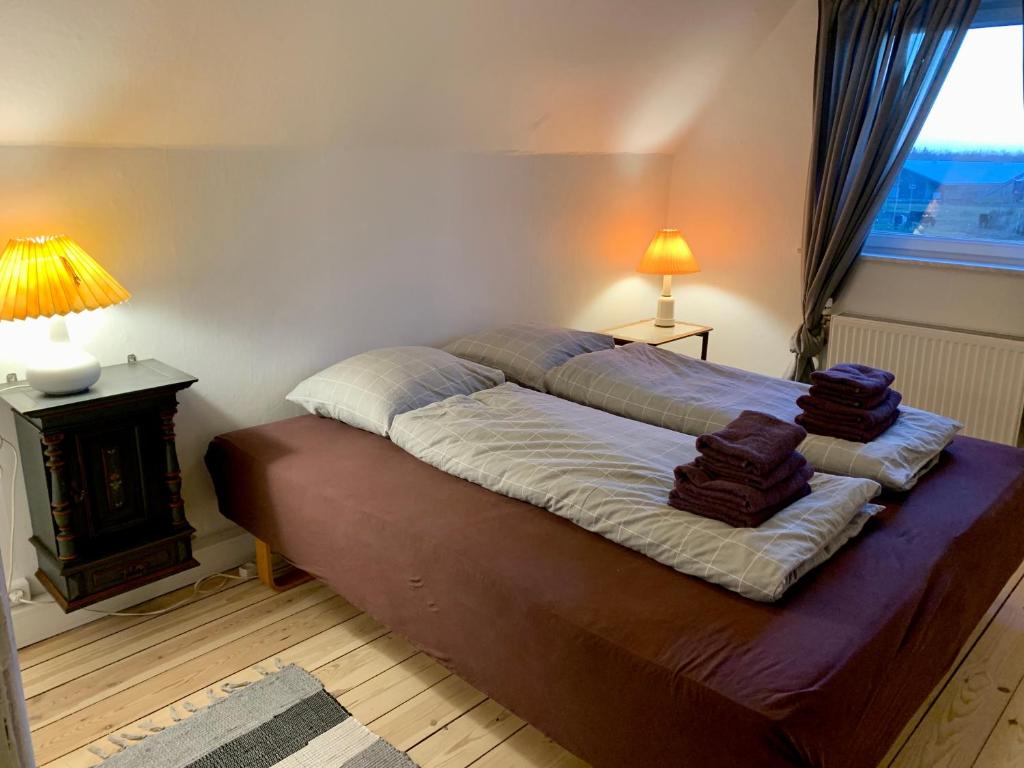 1 dormitorio con 1 cama grande y 2 almohadas en Jægergård en Skærbæk