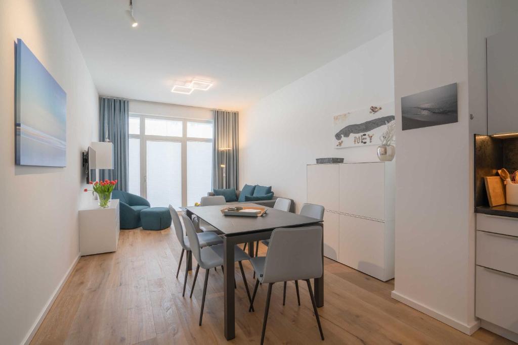 eine Küche und ein Wohnzimmer mit einem Tisch und Stühlen in der Unterkunft Meerkieker in Norderney