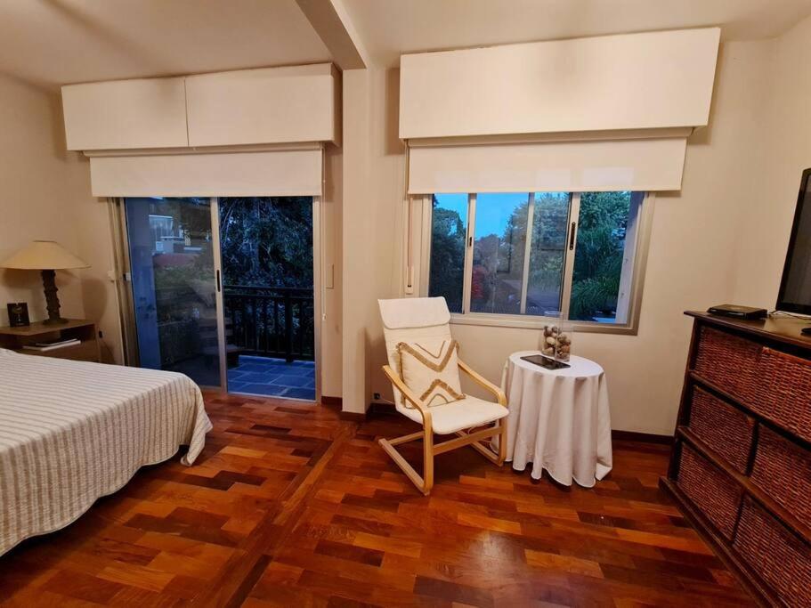 Hermosa habitación en apartamento en Carrasco - Comparte Apartamento conmigo في مونتيفيديو: غرفة نوم بسرير وكرسي وطاولة