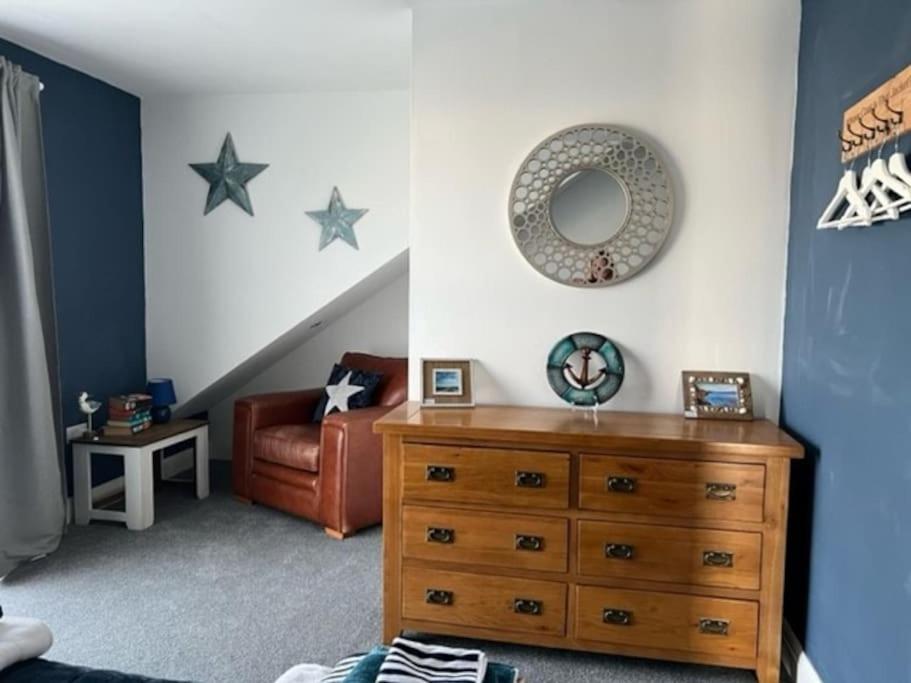 a room with a dresser and a chair with stars on the wall at Orchard Lodge -Coastal Retreat, new build, village views, private garden and terrace in Saint Brides Major
