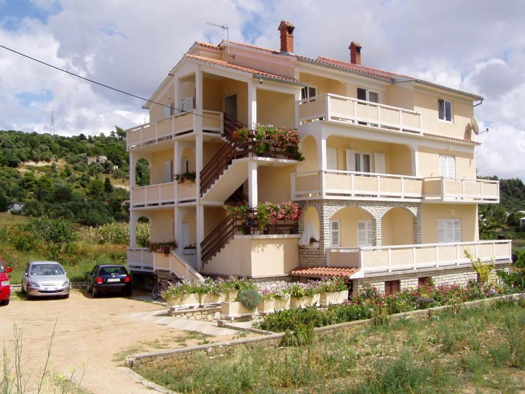 a building with cars parked in front of it at Apartments Beg in Rab