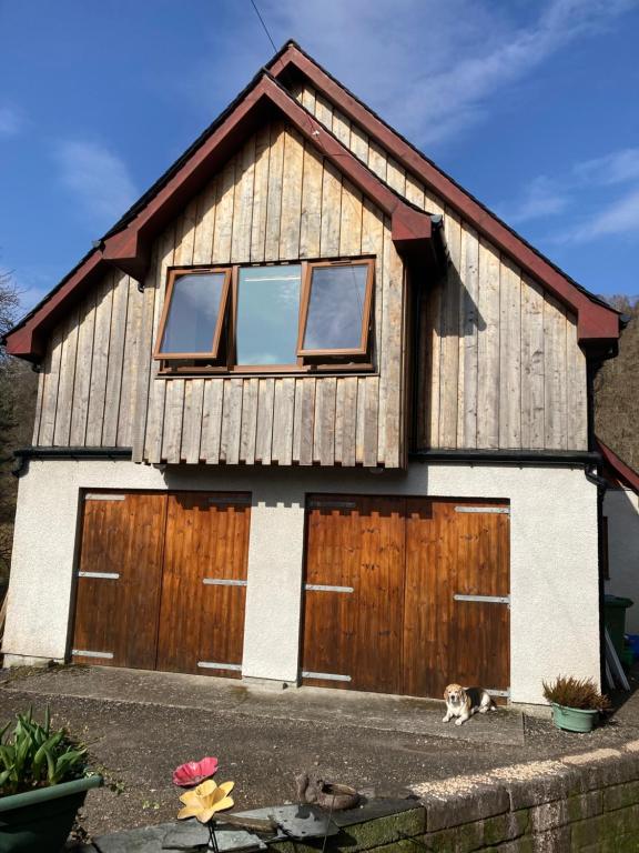 a house with a dog standing in front of it at Springbank Apartment - Sleeps 4 - Pet Friendly in Fort William