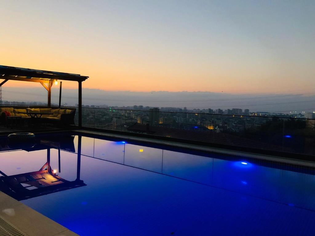 a swimming pool on the roof of a building at sunset at ORIGINE RENTALS AN2 in Hurmaköy
