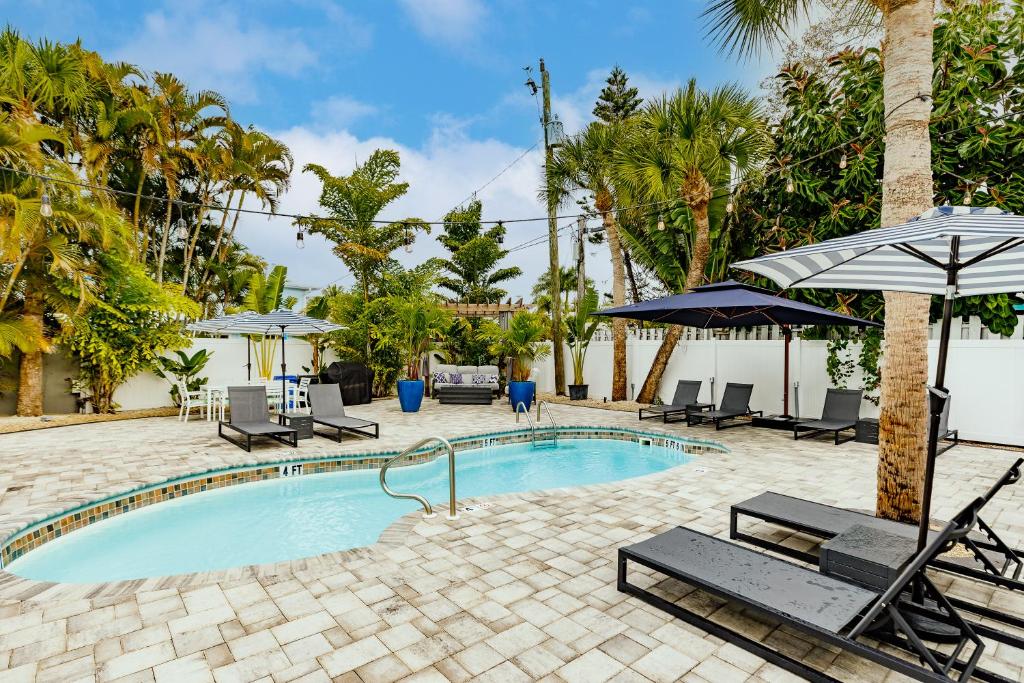 una piscina con sillas y sombrillas en un complejo en The Inn on Siesta Key en Siesta Key