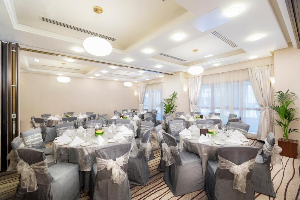 a banquet hall with tables and chairs in a room at Grand Mercure Majlis Residences in Abu Dhabi