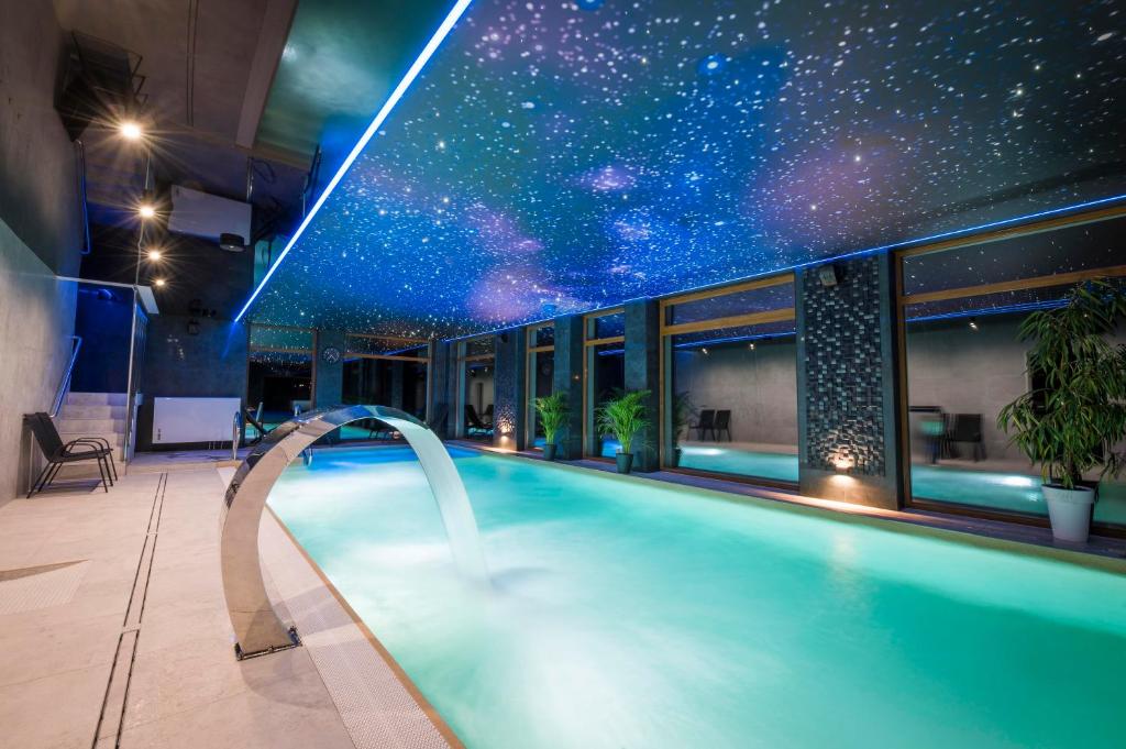 a swimming pool in a building with a star ceiling at Hotel Sailor Łeba in Łeba