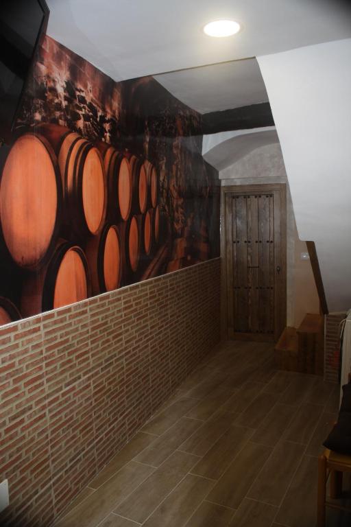 una habitación con un montón de barriles de vino en la pared en Casita La Glorieta en Peñafiel