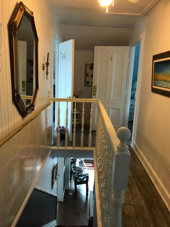 a hallway with a mirror and a stair case at gite des iles in Matane