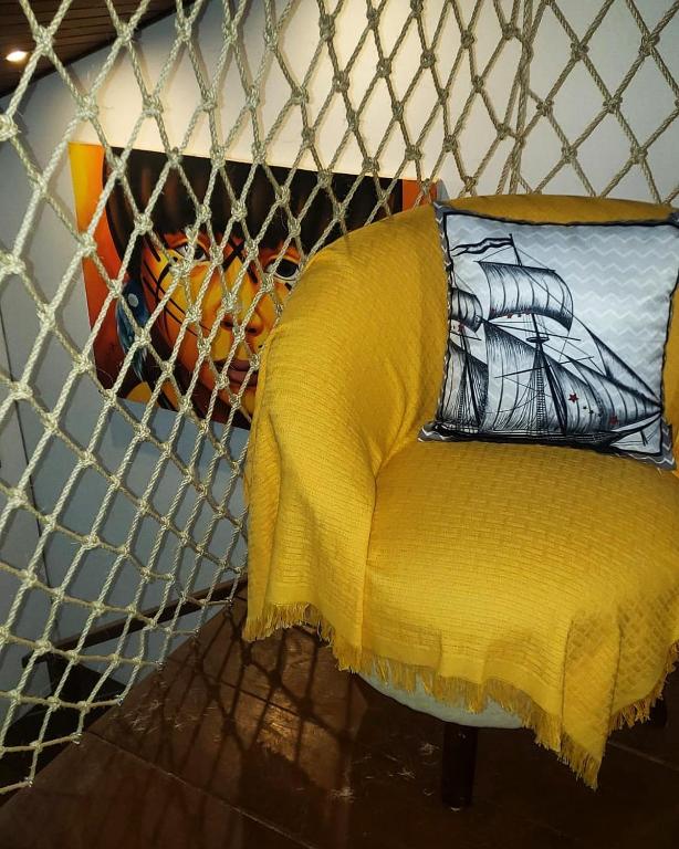 a yellow chair with a yellow blanket on it at Flat 14 Pipa in Pipa