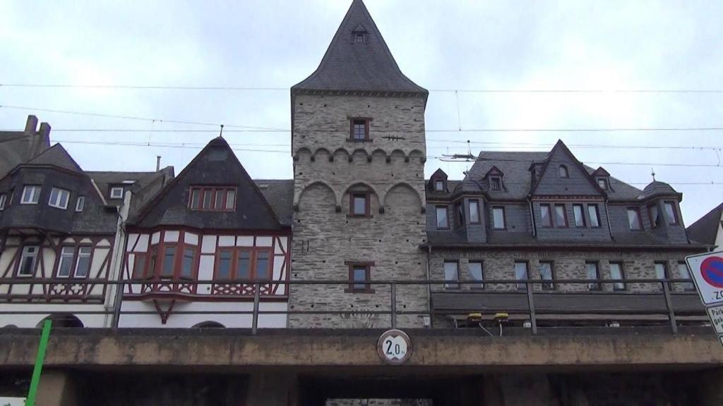 ein Gebäude mit einem Turm auf einer Brücke in der Unterkunft Kranenturm hotel in Bacharach