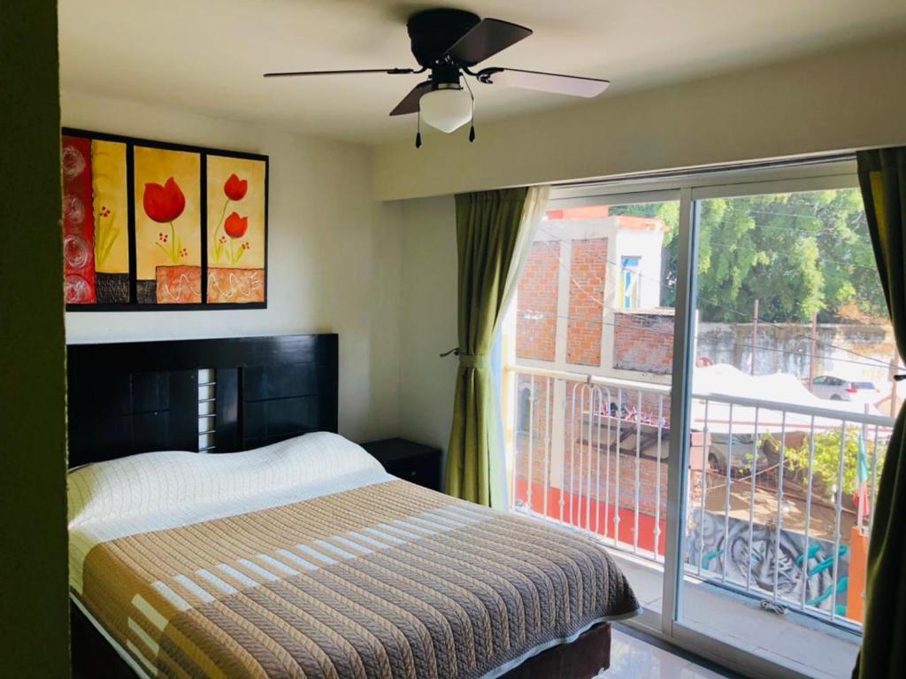 een slaapkamer met een bed en een groot raam bij Hotel Ruah in Cuernavaca