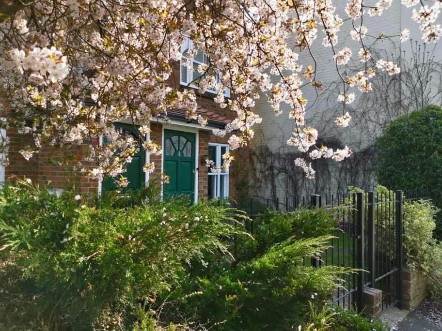 een huis met een groene deur en roze bloemen bij Flat 4 Summertown Court in Oxford
