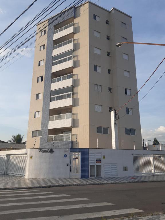a tall apartment building with a fence in front of it at Fermont 32 in Praia Grande