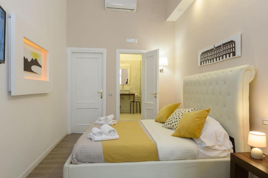 una camera da letto bianca con un letto e asciugamani di Domus Angioina a Napoli