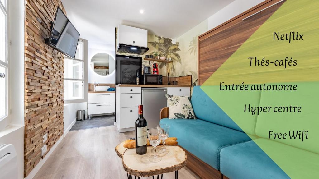 uma sala de estar com um sofá azul e uma cozinha em Chez Ingres - Le Nid - Joyau caché en centre ville em Montauban