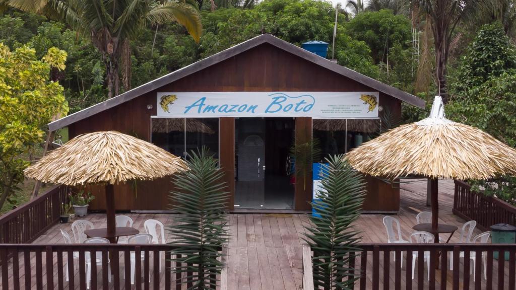 un ristorante con sedie e ombrelloni di fronte di Amazon Boto Lodge Hotel a Careiro
